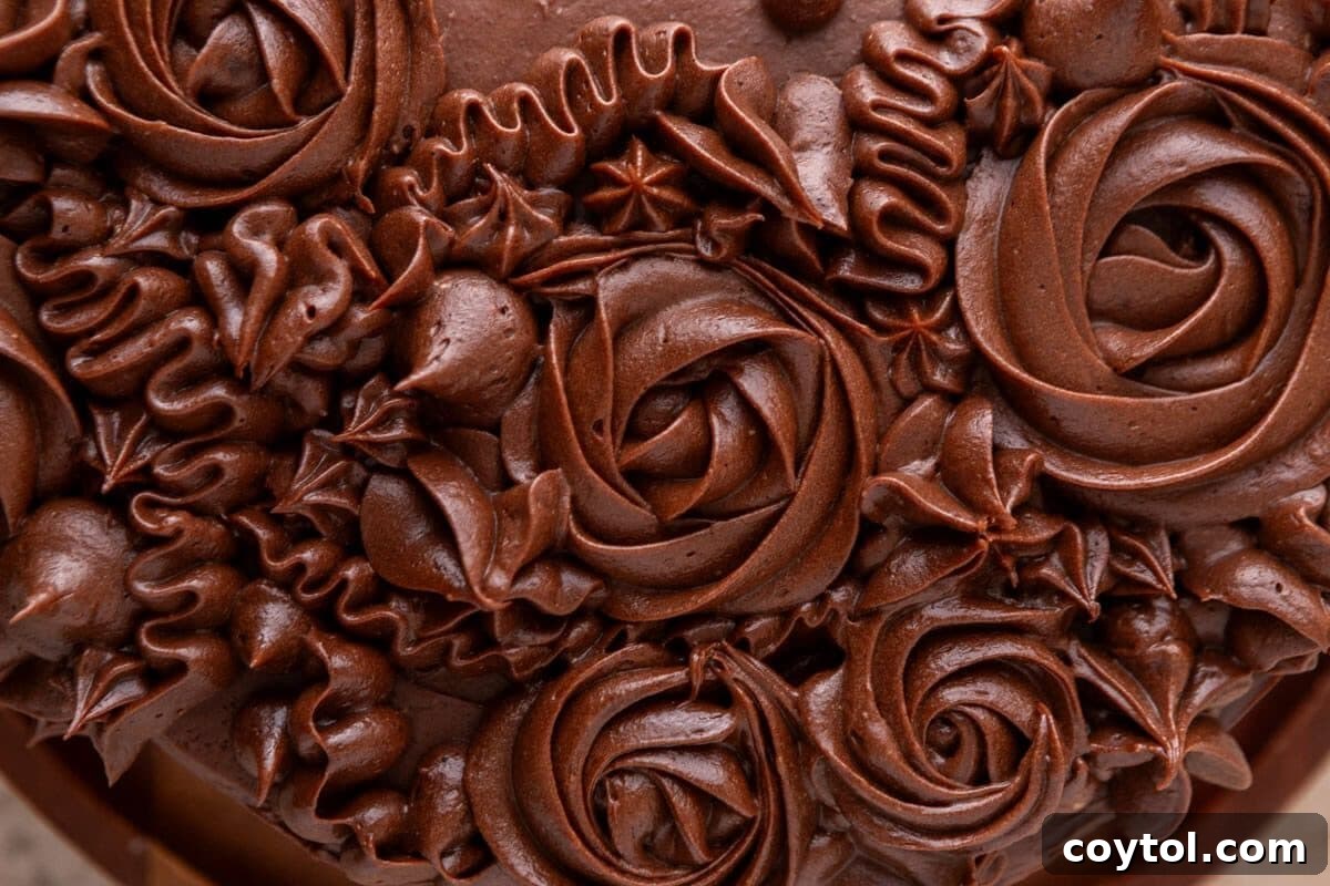 Close-up photograph of smooth, silky chocolate cream cheese frosting, emphasizing its creamy, fudgy texture and rich dark color, highlighting its deliciousness
