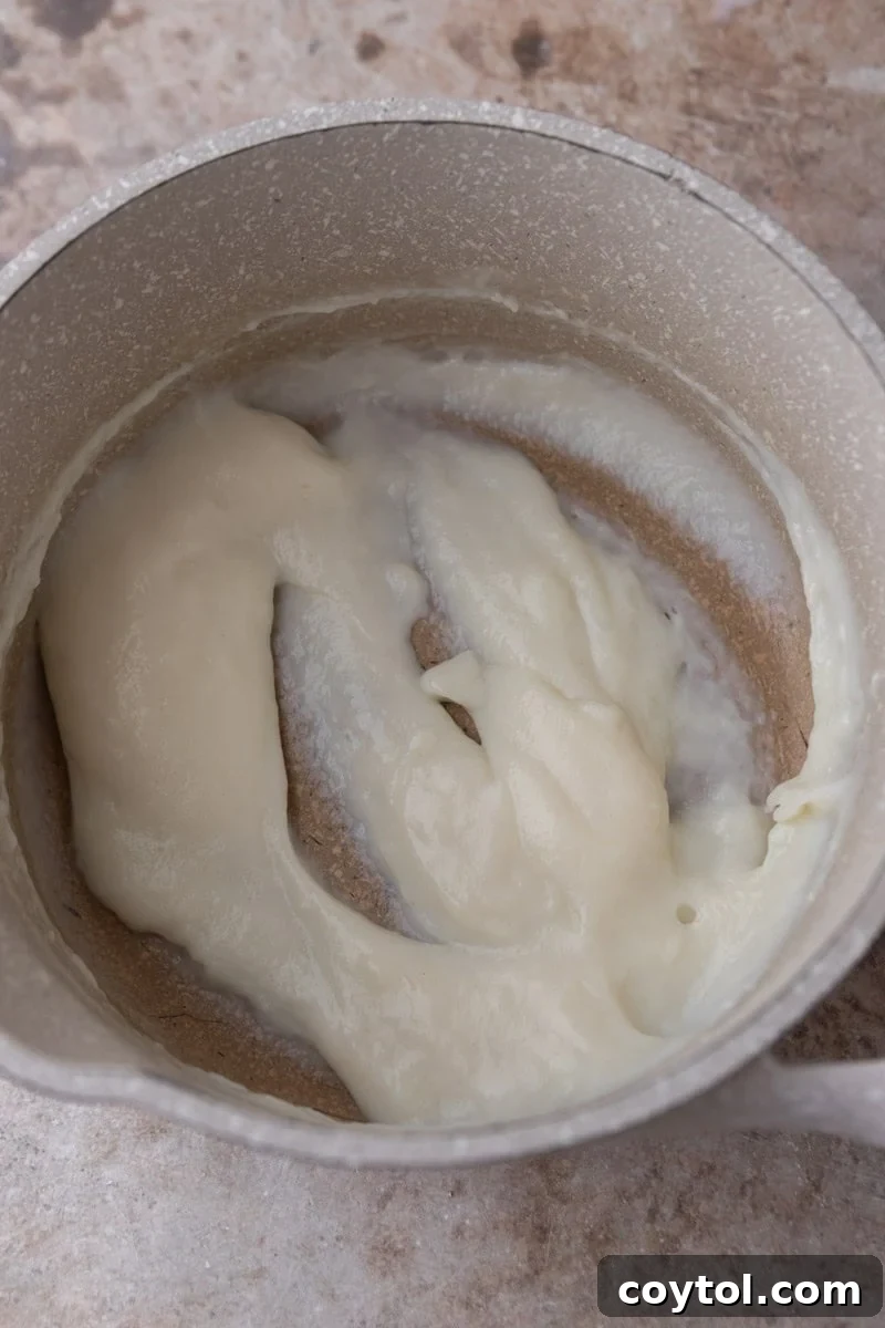 The cooked tangzhong paste is shown in the saucepan, thick, glossy, and holding its shape.