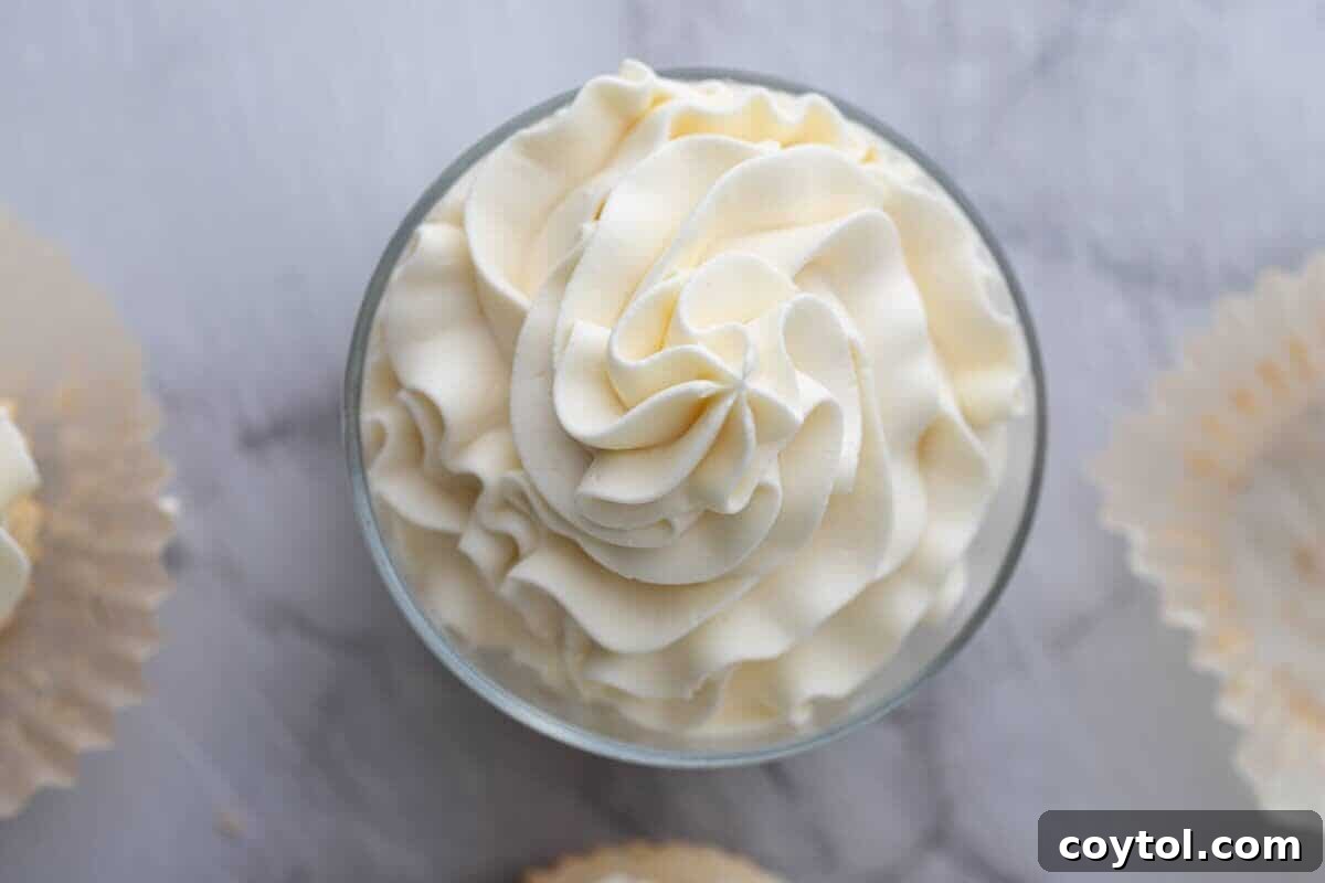 A glass bowl filled with light and fluffy mascarpone frosting, beautifully piped and ready to adorn a special Mother's Day cake or dessert.