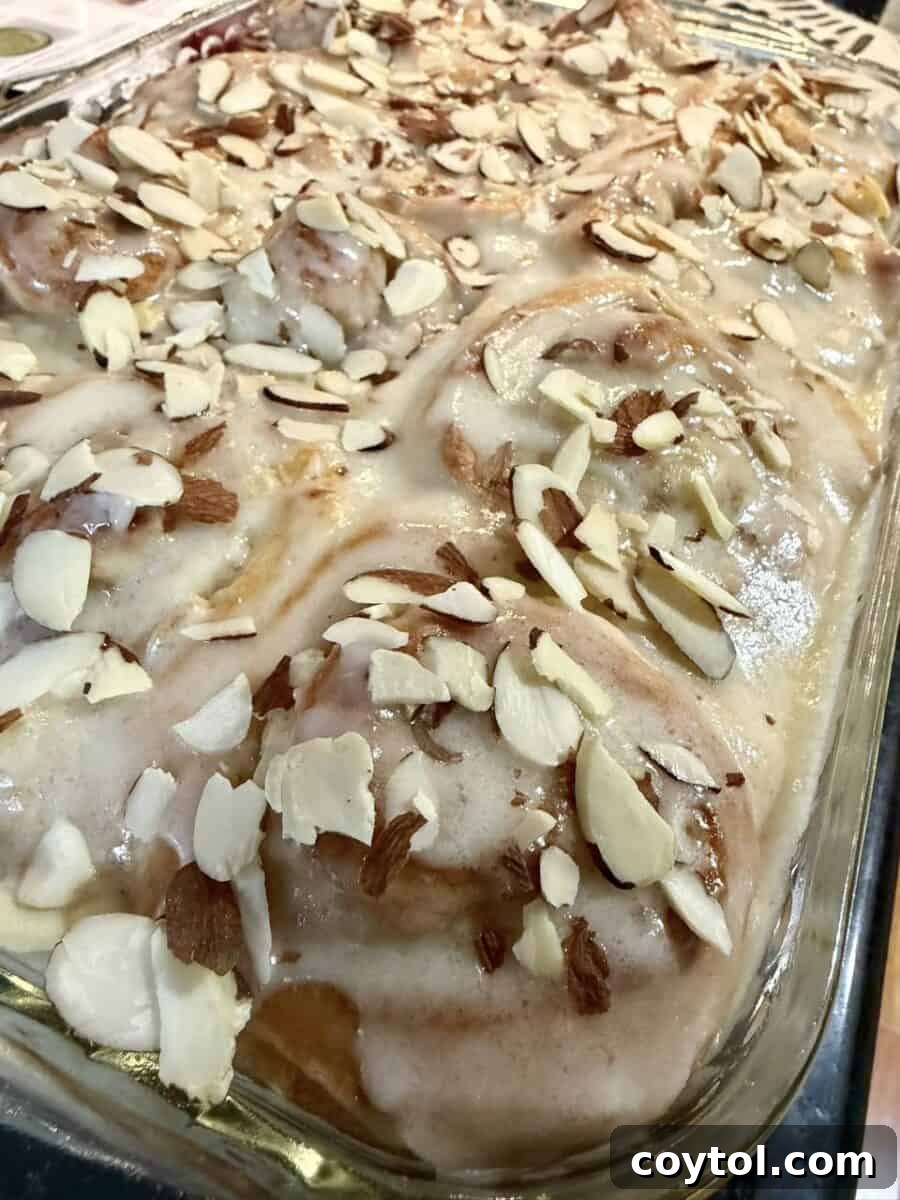Glazed almond cinnamon rolls topped with sliced almonds, a past Loaf BakeClub featured recipe
