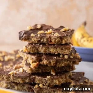 Stack of banana bread Christmas crack pieces on a plate with a banana in the background.