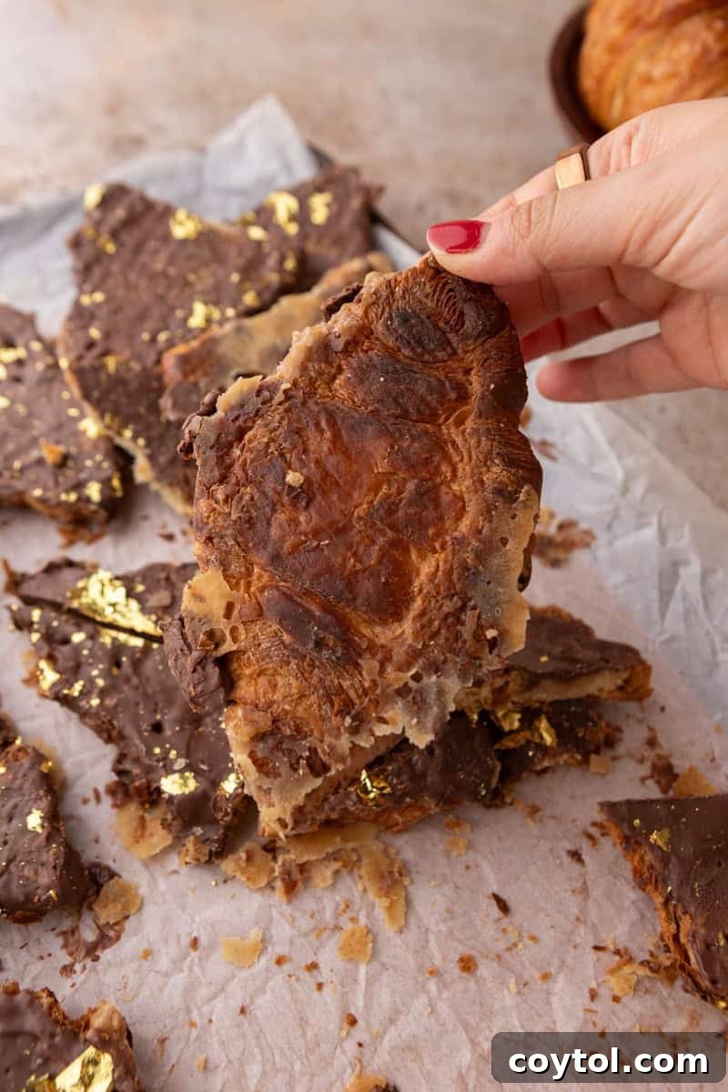 Underside of a croissant Christmas crack piece showing toffee soaked into the flaky croissant layers
