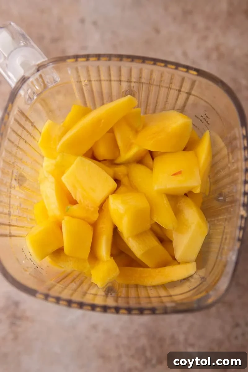Fresh mango chunks in a blender before blending smoothly