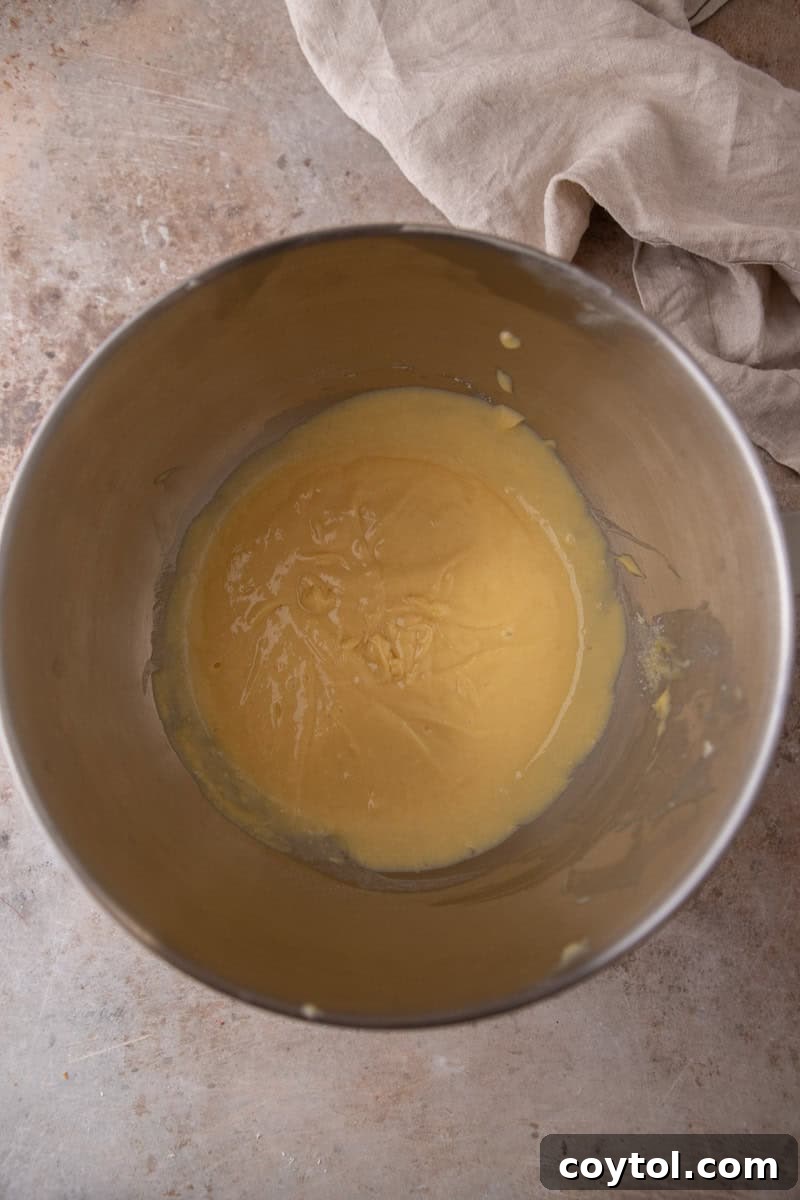 Smooth vanilla cake batter in a stainless steel mixing bowl.