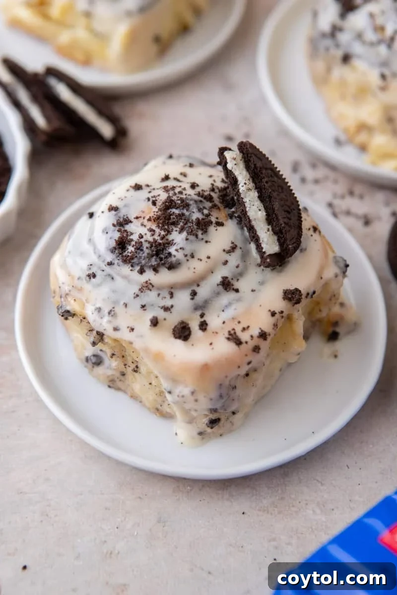 Oreo cinnamon roll topped with cream cheese glaze, crushed Oreos, and a half Oreo cooki