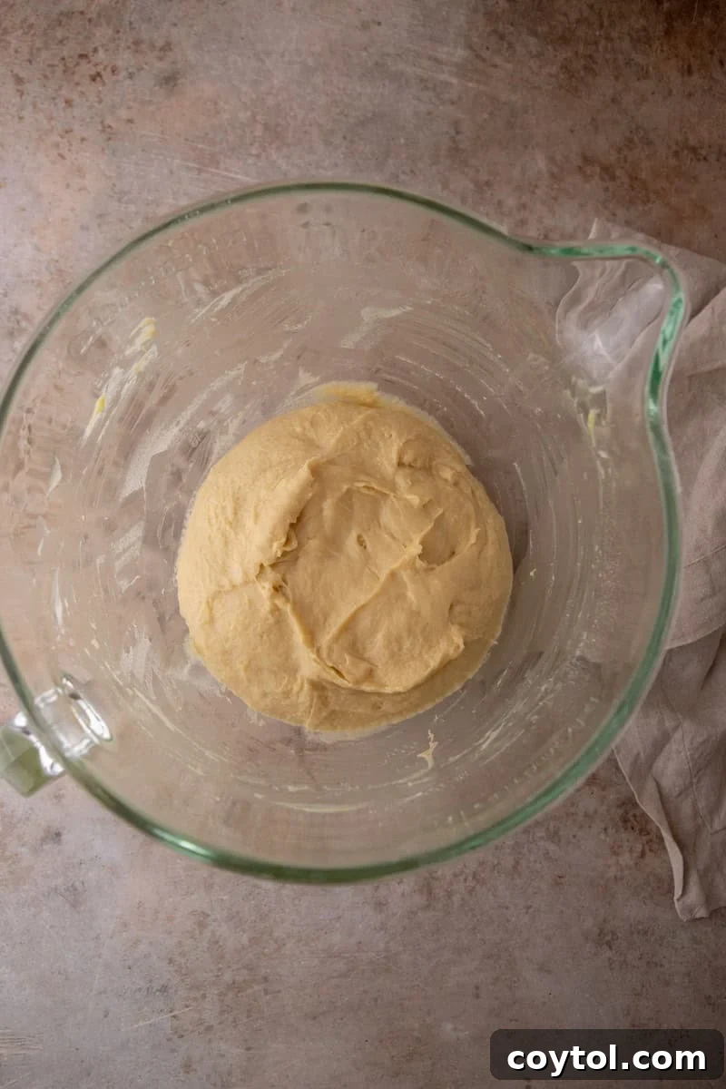 Soft brioche dough ball in a glass bowl before the first rise