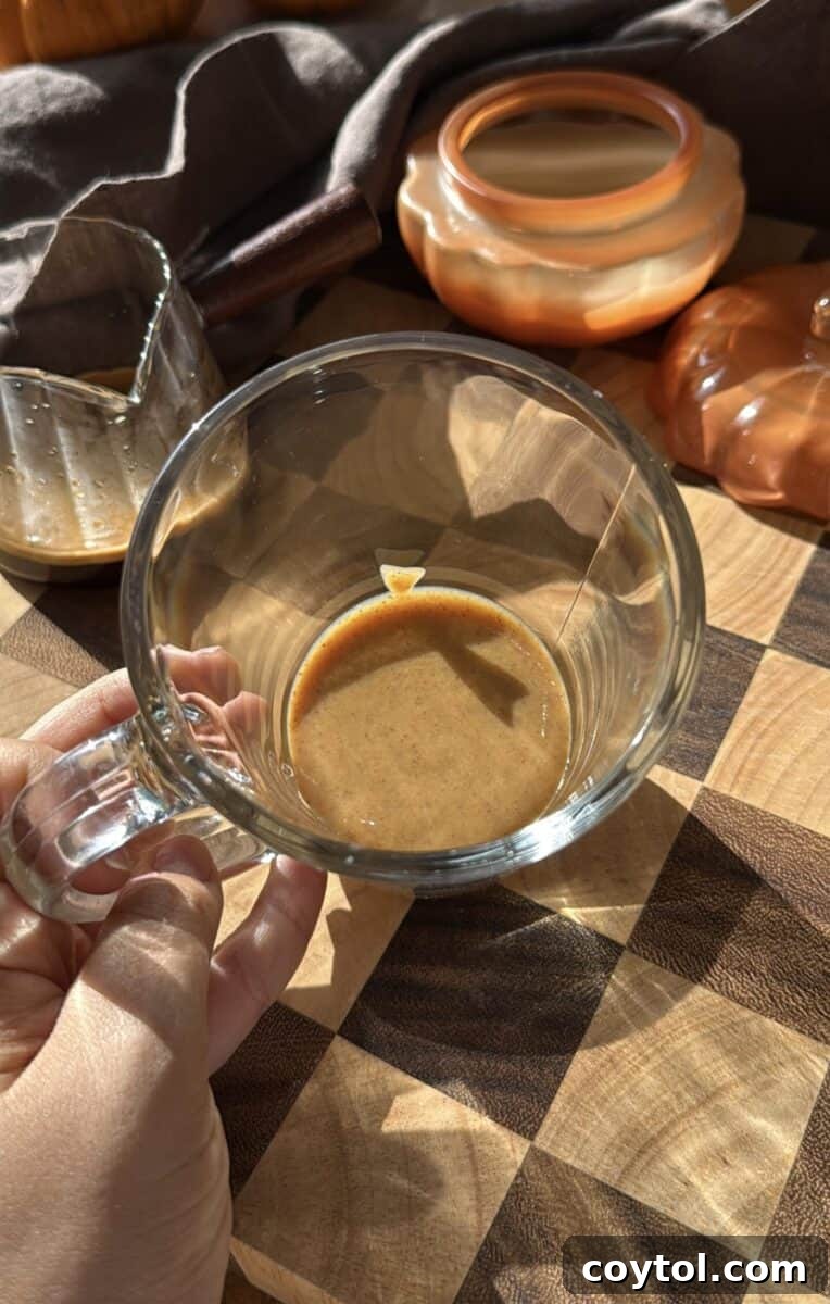 Pumpkin spice sauce in a tall glass mug.